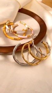 Dettaglio di bracciali vintage stile bambù a forma di C con finitura in smalto colorato