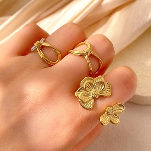 Goldenes Ring-Set mit unregelmäßiger Blume und Knoten auf Seide für einen Luxus-Look