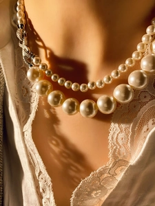 Detalle de collar de perlas de dos capas con cuentas graduadas y cierre plateado