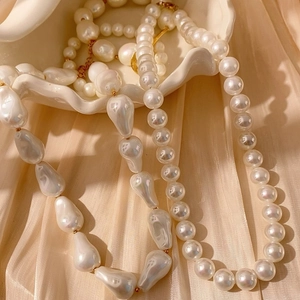 Elegante collar de perlas de varias capas con perlas barrocas sobre concha blanca y seda
