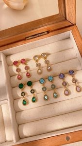 Details von Vintage Gold-Ohrhängern mit bunten Kristallen in einer Schmuckschatulle
