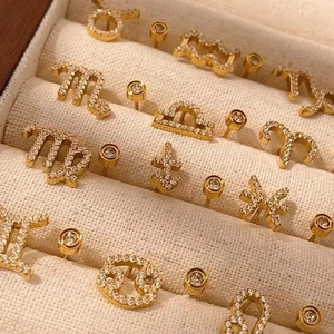Parure de boucles d'oreilles constellations dorées serties de zircons dans un écrin à bijoux