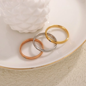 Tre anelli minimalisti in oro, argento e oro rosa con una piccola pietra incastonata