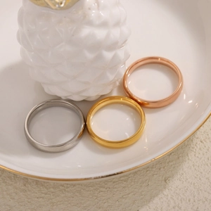 Set di anelli lucidi in argento oro e oro rosa su un elegante piatto bianco decorato