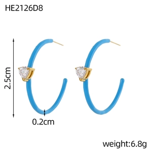 Detail van blauwe C-vormige oorringen met hartvormige zirkoon en 2,5 cm diameter