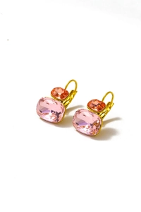 Detalle de pendientes dorados con circonitas rectangulares rosas y naranjas