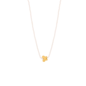 Detalle de un collar de perlas blancas con un colgante de trébol dorado pulido