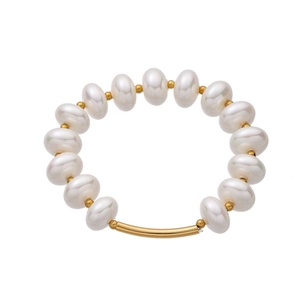 Dettaglio del bracciale di perle con perline dorate e un tubo metallico dorato ricurvo
