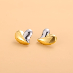 Détail de boucles d'oreilles cœur au design poli bicolore divisé en or et en argent