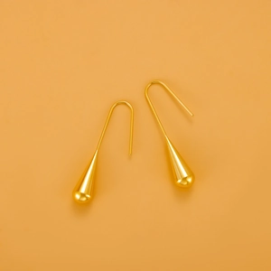 Detailansicht der polierten goldenen Tropfenohrringe mit langen Haken im minimalistischen Stil