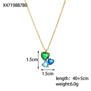 Macro view of gold pendant featuring three heart-shaped green and blue zircons