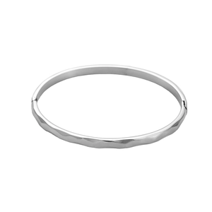 Macro detail of silver hammered texture on titanium steel hinged bangle with glossy finish