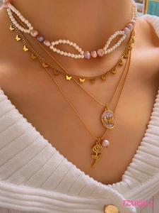 Detail of layered gold necklace with butterfly pendant and small imitation pearls