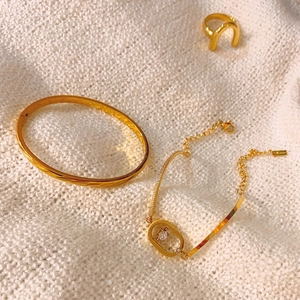 Set de joyas doradas con brazalete grabado, pulsera de piedras y un anillo en forma de U