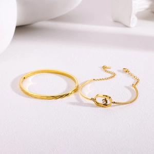 Conjunto de brazalete dorado trenzado y pulsera con cristales blancos sobre piedra