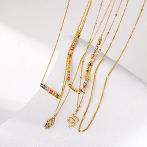 Dettaglio di quattro collane d'oro con mano di Fatima, serpente e pendenti in zircone