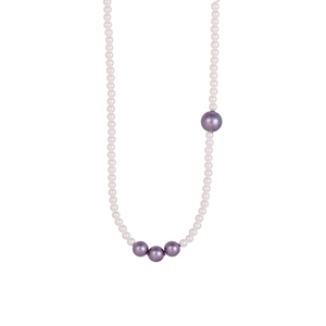 Dettaglio collana asimmetrica di perle con perline bianche e quattro grandi perle viola scuro