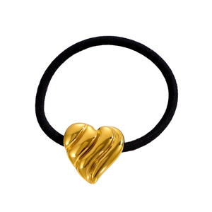 Détail d'un pendentif coeur en métal doré texturé sur un élastique à cheveux noir flexible