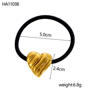 Vue détaillée d'un élastique à cheveux noir avec breloque coeur doré de 5,0 cm de diamètre
