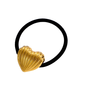 Détail d'un accessoire pour cheveux avec cœur doré et texture métallique radiale