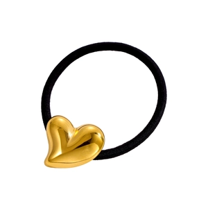 Gros plan d'un pendentif cœur doré sur un élastique noir avec finition miroir