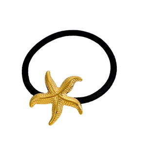 Détail du pendentif étoile de mer dorée texturée sur un élastique à cheveux noir robuste