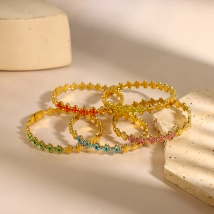 Exquise goudkleurige armbandset met klavertje vier en levendige gekleurde zirkonia