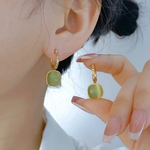 Elegant gold drop earrings with square green gemstone pendants and sparkly white rhinestones