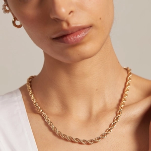 Gros plan d'une chaîne corde dorée de 4mm et boucles d'oreilles assorties sur un mannequin