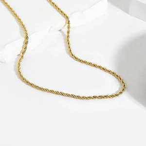 Vue rapprochée d'une chaîne corde dorée en acier inoxydable sur un support en pierre