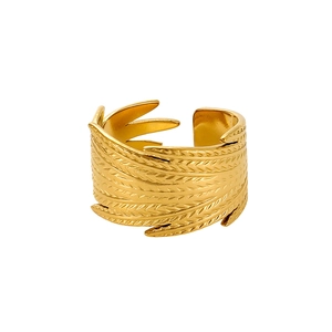Detail of vintage golden open ring featuring intricate feather embossed texture on metal