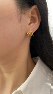 Detail view of model wearing vintage gold leaf earrings with textured bamboo leaf design