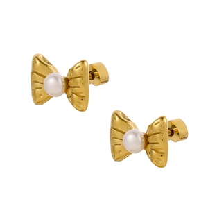 Detailed view of gold bow earrings featuring a lustrous round white pearl center