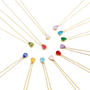 Macro shot of colorful pear-cut crystal teardrop pendants with golden claw settings