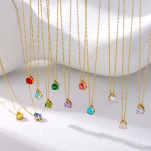 Detail view of colorful pear-shaped crystal pendants on thin gold-plated necklaces