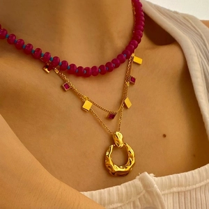 Minimalist layered necklace set with magenta beads and molten gold pendant on model