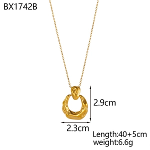Gold beaded necklace featuring irregular textured ring pendant on a clean white background