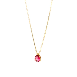 Detail of red teardrop gemstone pendant on a gold chain necklace with claw setting