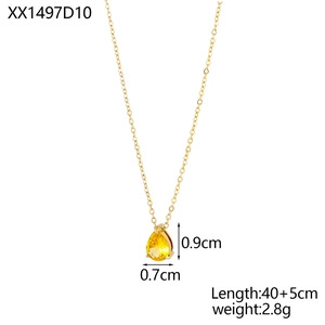 Macro shot of gold chain necklace with yellow teardrop crystal pendant in prong setting