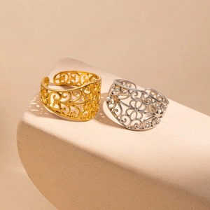 Detailed close-up of gold and silver filigree mesh rings on stone display stands
