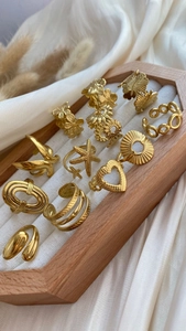 French chic gold plated stainless steel rings with floral and geometric charms in tray