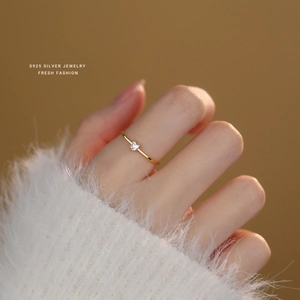 Close-up of heart-shaped white zircon ring in 18k gold plated silver worn on a finger