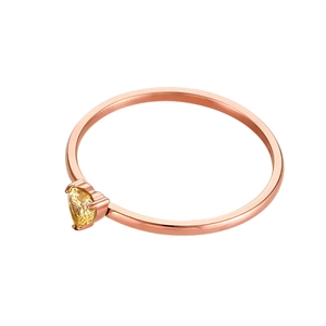 Detail of a 18k rose gold ring featuring a yellow heart-shaped gemstone in prong setting