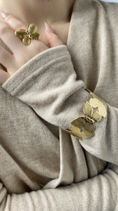 Détails du bracelet et de la bague papillon dorés avec une finition en métal texturé