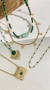 Detail of layered bohemian necklaces featuring green stones, gold pendants, and evil eye charm