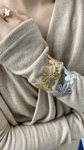 Détail de bracelets fleurs or et argent avec texture métal brossé et design floral 3D