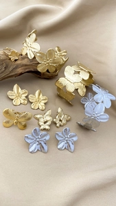 Détail macro de bracelets fleurs or et argent sur fond élégant en soie et bois naturel