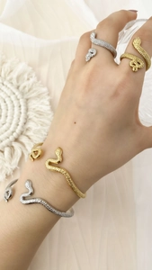 Details des schlangentexturierten Schmucksets mit Armreifen und Ringen in Gold und Silber