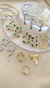 Detailaufnahme der Schlangenschmuck-Kollektion mit Schuppen und eingelegten Augen auf Seide