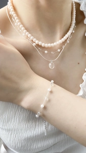 Detailed layered necklace set with pearls and crystal beads on a female model